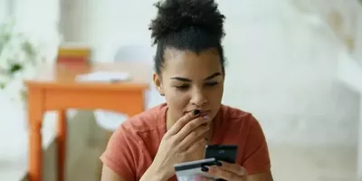 En dame ser på et bankkort. Foto