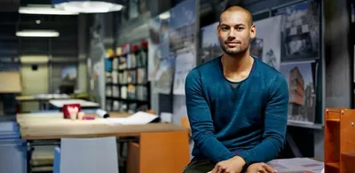 En mann sitter på en pult. Foto