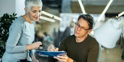 En mann signerer på en blokk. Foto